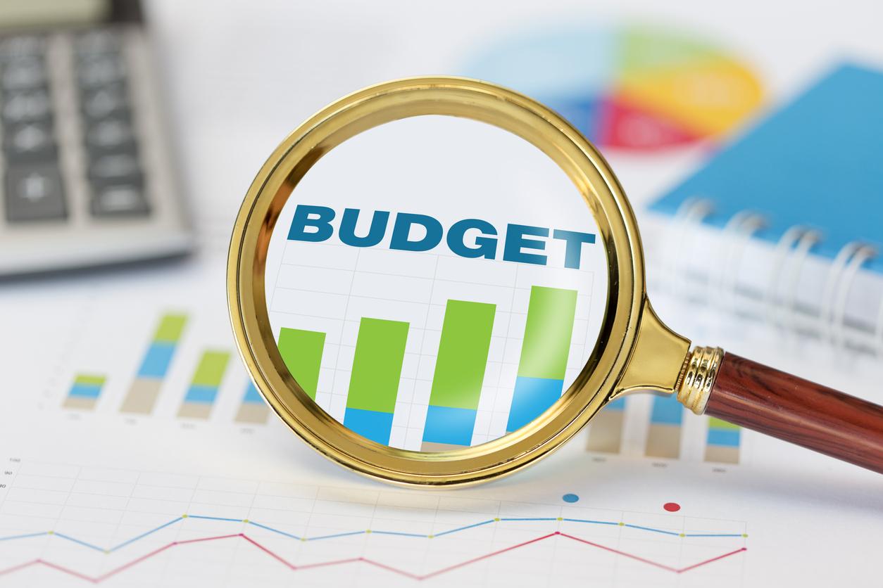 Magnifying glass and calculator on budget graph